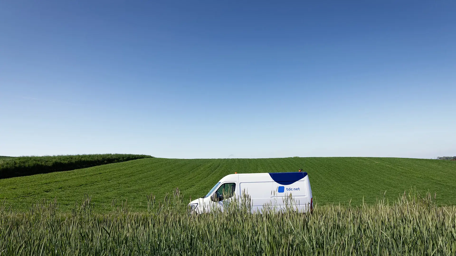 Teknikerbil kører ved kornmark